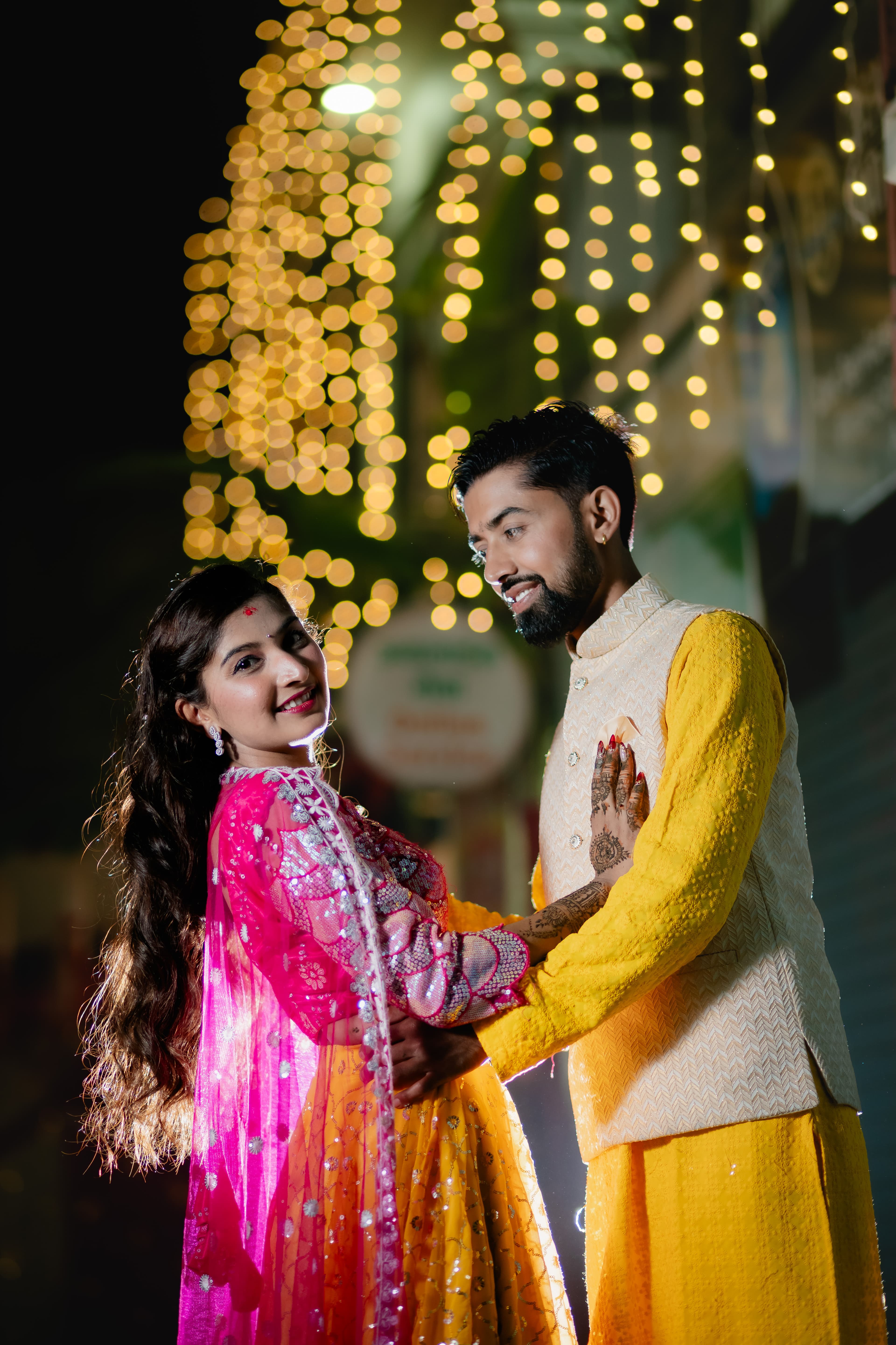 Mehendi Couple Embrace with Fairy Lights